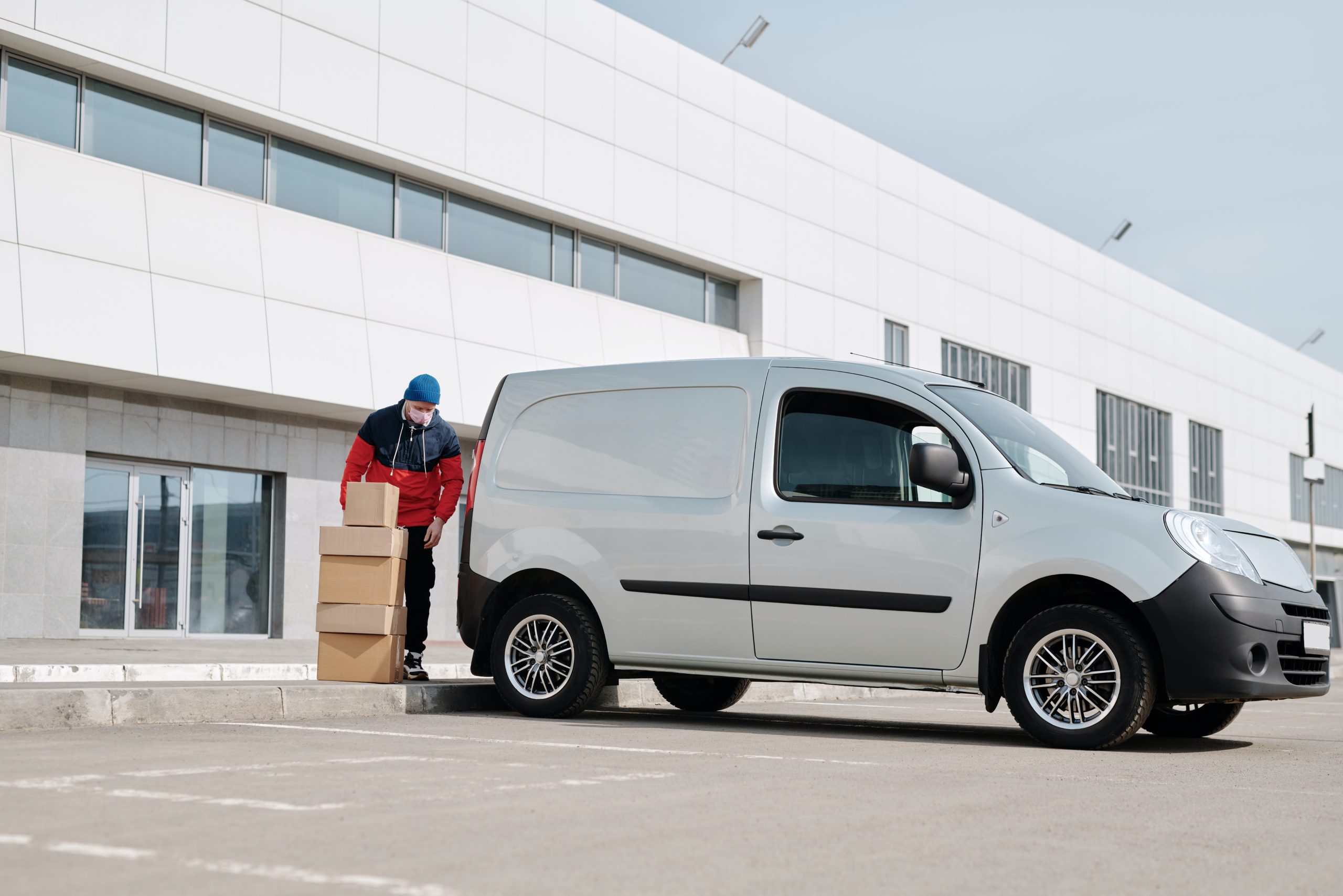 Mann lädt Kartons in einen Transporter