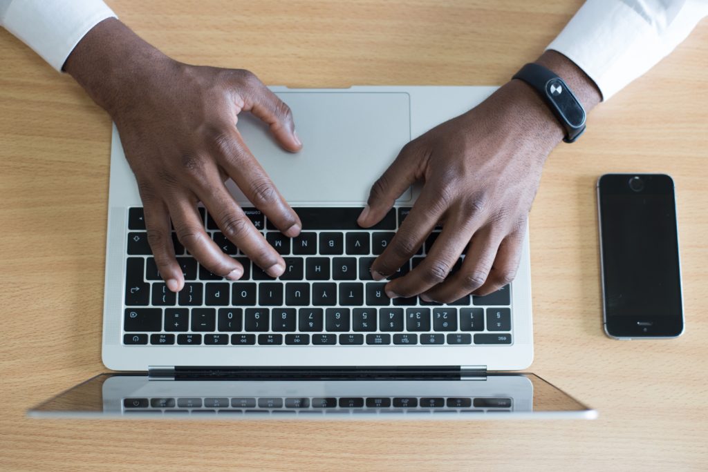 Digitaler Posteingang: Hände tippen auf einer Laptoptastatur
